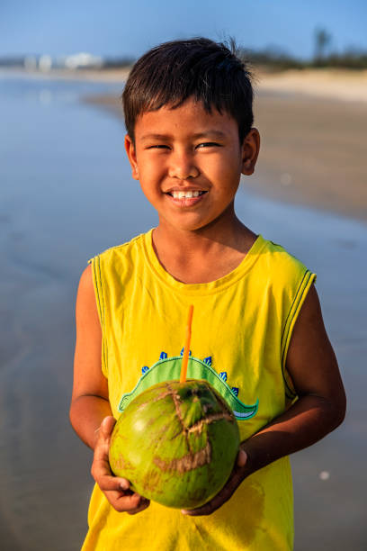 istock Vietnamese boy holding coconuts on the beach, Vietnam 2164620897