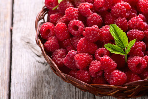 istock Raspberry in a basket .on wooden background 2164621192