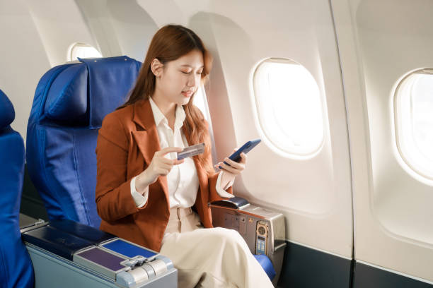 istock A businesswoman travels abroad on a plane, using her computer during the flight. She experiences jet lag, suffering from headaches, neck pain, and stomach ache due to the long journey. 2164621514