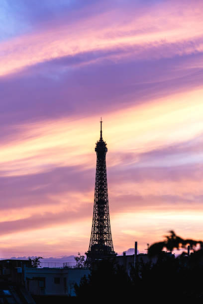 Dusk on Tour Eiffel. Top and detail of Eiffel Tower against beautiful and colored sunset in background,  symbol of Paris and France. July 27, 2024
