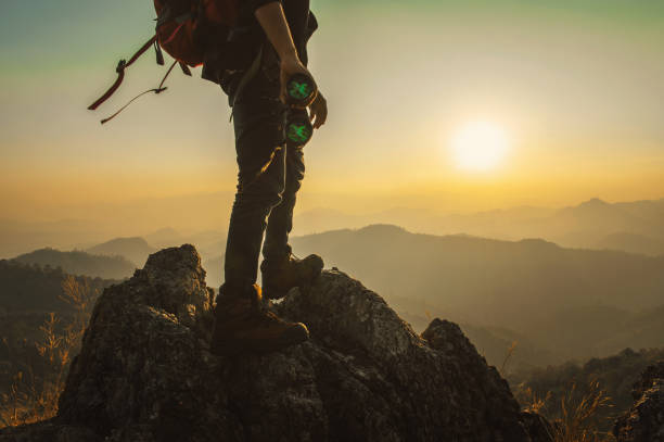 istock man is standing on a mountain top with a pair of binoculars in his hands 2164629244