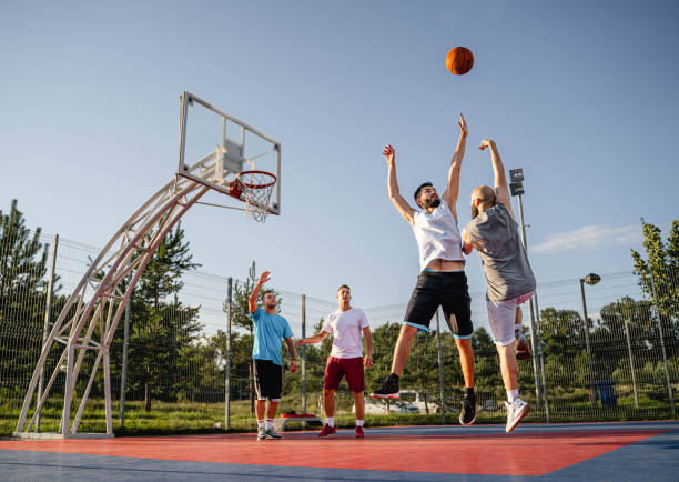 istock Four male friends playing basketball 2164630176