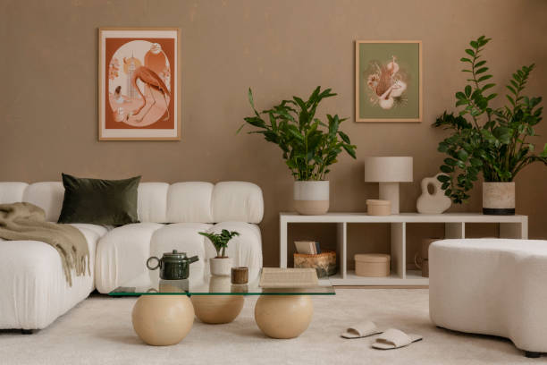 Warm and cozy, autumn beige composition of living room interior with green plants, mock up poster frame, art, boucle sofa, stylish coffee table, patterned rug, marble lamp and personal accessories. Home decor. Template. cálida y acogedora, composición beige otoñal del interior de la sala de estar con plantas verdes, marco de póster de maqueta, arte, sofá boucle, elegante mesa de café, alfombra estampada, lámpara de mármol y accesorios personales. decoración del h
