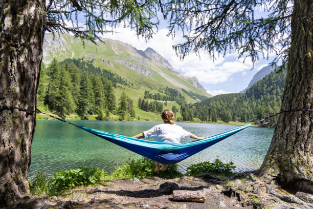 istock Woman in Hammock Overlooking Mountain Lake 2164637341