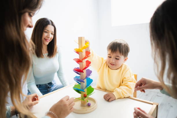 istock Autistic boy playing with teachers in a special school 2164637403