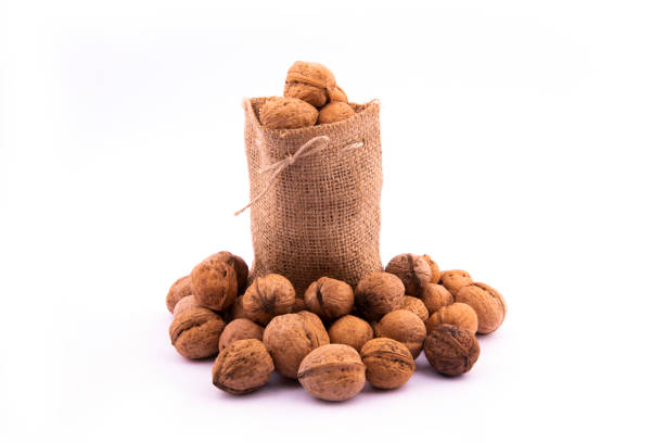 shelled walnuts in knitted sack on white background. shelled walnuts in linen sack