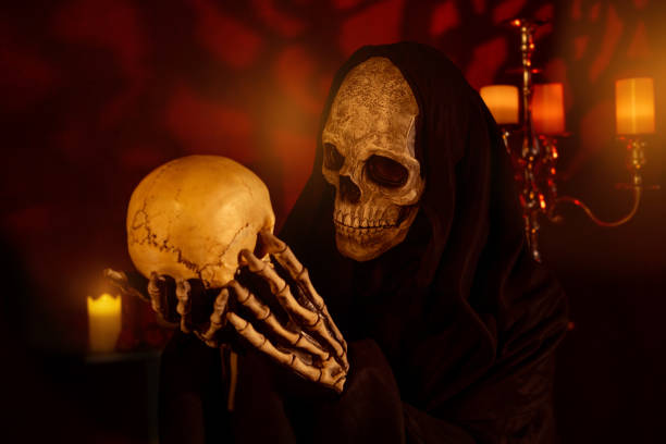 istock Grim Reaper holding and talking to a skull. 2164642163