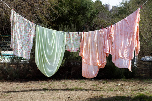 Woman hangs her laundry on the balcony on a sunny day