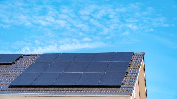 istock Solar Panels Harnessing Sun Energy on Rooftop Under Clear Blue Sky 2164649716
