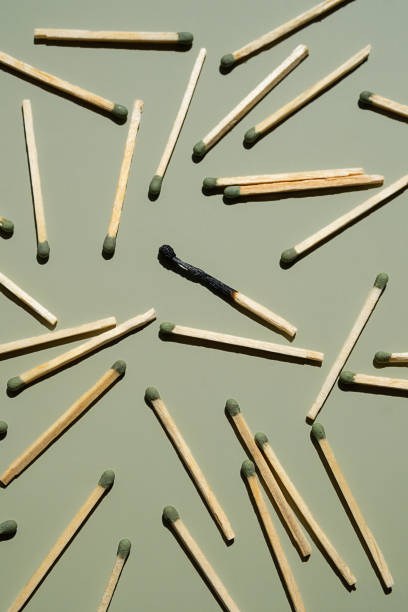 istock Scattered matches with one burnt matchstick on light green background. 2164652609