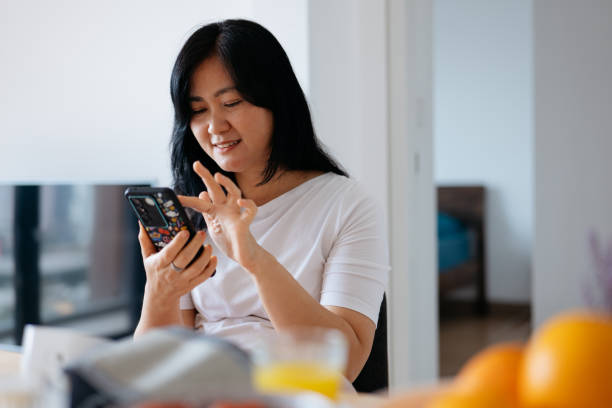 A mature asian woman using smart phone to check on healthy eating article