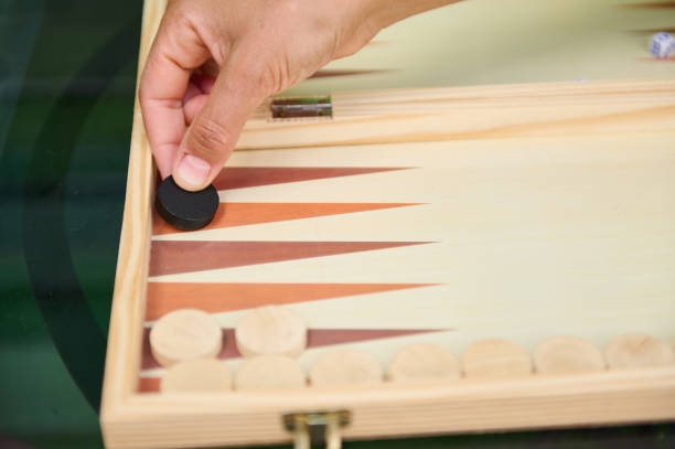 istock Hand placing chip in backgammon game on wooden board 2164653207