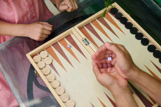 istock Children playing backgammon on a glass table, enjoying a classic board game 2164653283