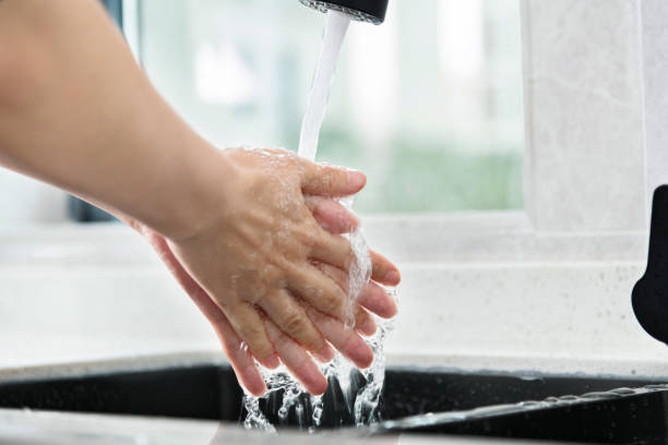 istock Woman washing hands under running water 2164655694