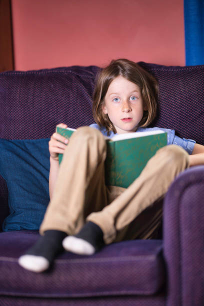 istock Seven-year-old boy reading in an armchair 2164657803