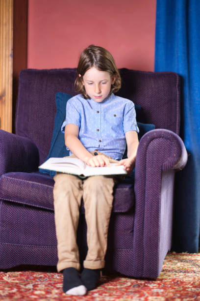 istock Seven-year-old boy reading in an armchair 2164657842