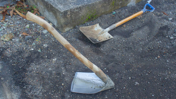 istock Dirty hoe and shovel on black sand for construction tool 2164658160