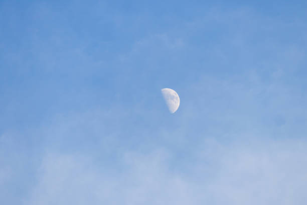 Blue sky with half moon, moon in a day.