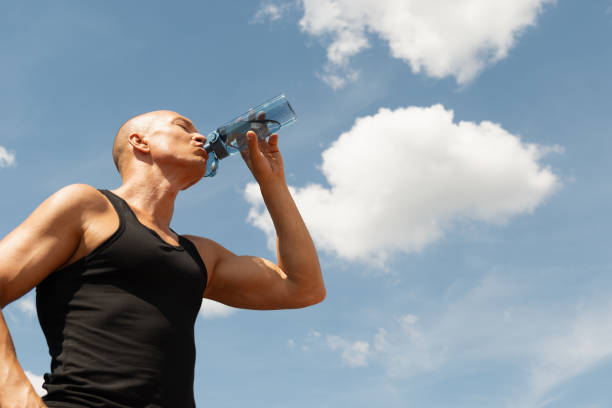 istock Athletes man drinking water on against sky. Outdoors. Water balance for for active workout. 2164661892