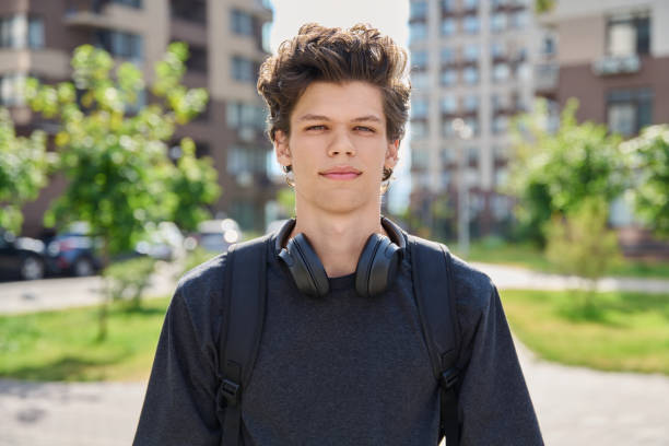 istock Handsome young man looking at camera outdoors, city street background 2164665702
