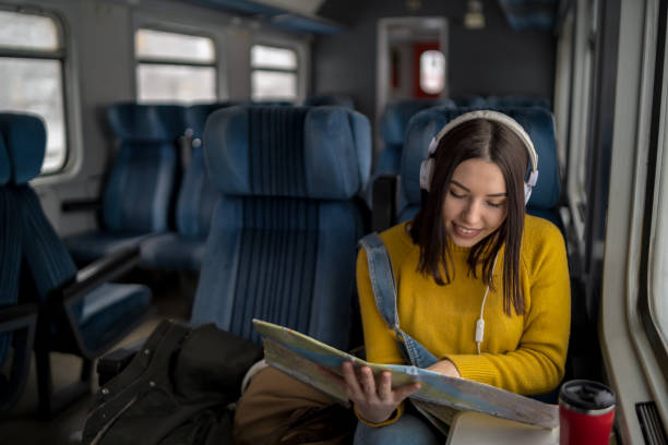 istock A young trendy traveler is sitting next to a train window and looking through it. 2164666482
