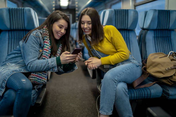 istock Cheerful Girlfriends Laughing In Train 2164666612
