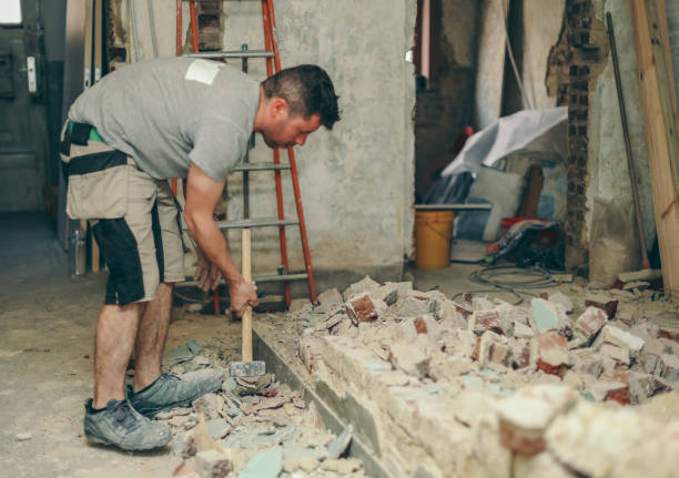 istock A young man breaks a brick wall with a sledgehammer. 2164671253