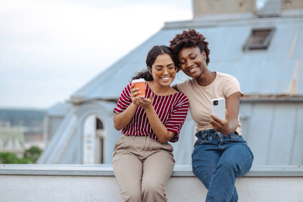 istock Two female friends cheerfully chatting and having coffee 2164671413