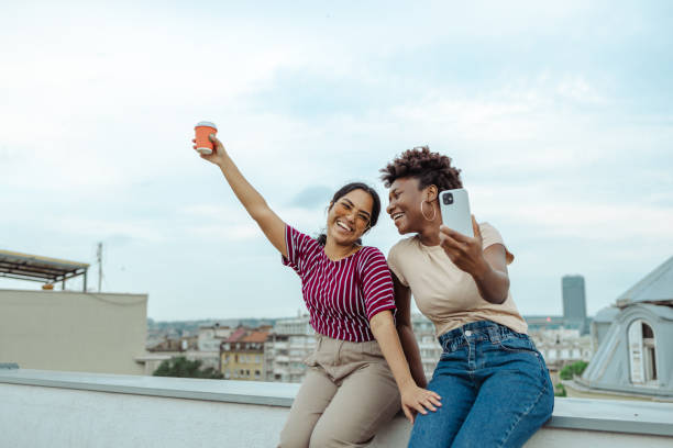 istock Two multiracial female friends taking a selfie on a rooftop 2164671798