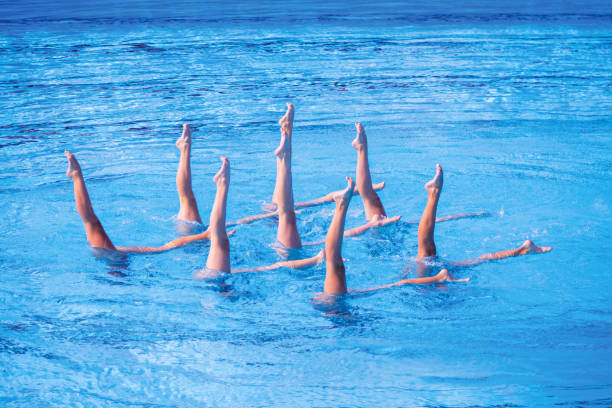 istock Synchronized female artistic swimming team performing synchronized legs movement in swimming pool 2164674395