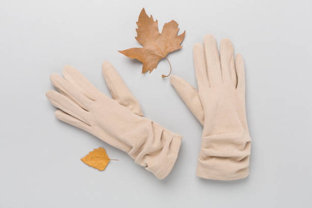 istock Beige gloves on color background, top view 2164675153