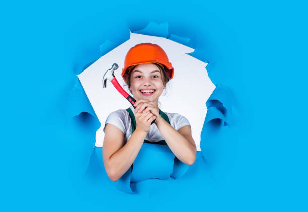 happy kid engineer with hammer tool in hard hat, industry.