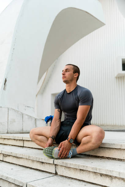 istock Young man doing exercise and taking a training outdoors 2164683477