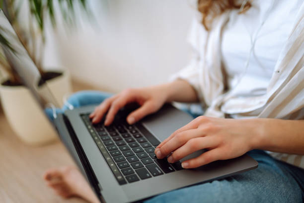 Woman working at home office hand on keyboard close up.