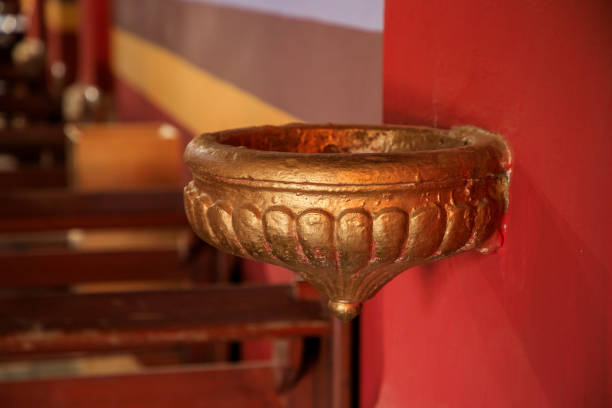 Close-up of a liturgical piscina embedded in the wall of a Catholic church. Traditionally used for disposing of holy water or cleaning sacred vessels during religious rites and sacraments.