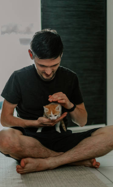 istock Portrait of a man stroking a small kitten. 2164697000