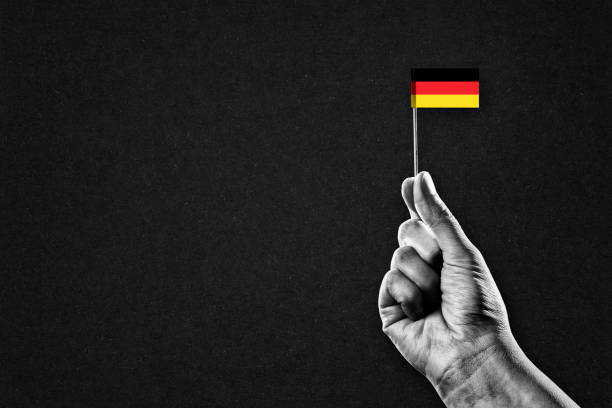 Hand in Black and White Holding Flag of Germany, Copy Space