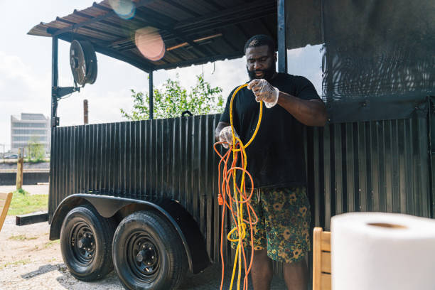 istock BBQ Food Truck Owner untangling two Electrical Extension Cords while Setting up for a lunch catering event 2164702752