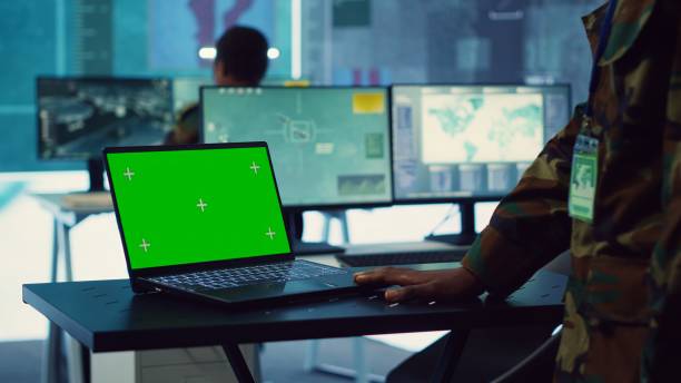 istock Commander examines a greenscreen on laptop in military command center 2164703927