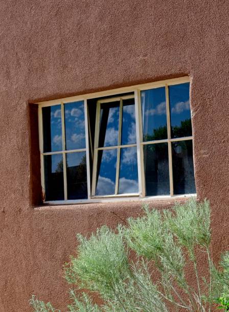 istock Old window with reflection of adobe stucco wall 2164704995