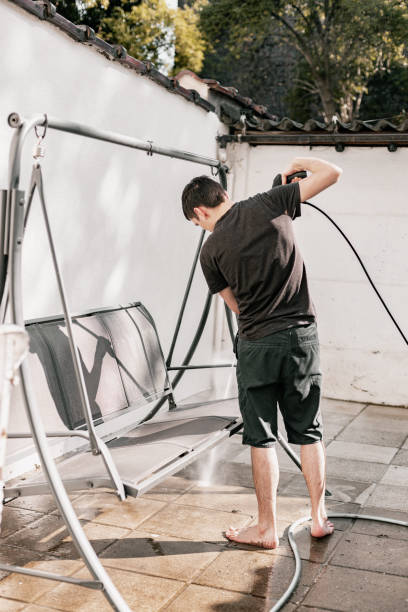 istock A young guy washes a garden swing with a kercher. 2164708424