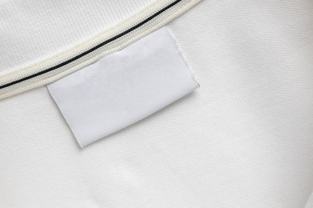 istock Blank white laundry care clothes label on white shirt fabric texture background 2164712023