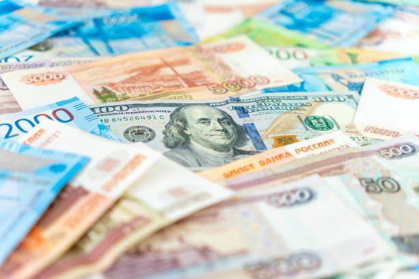 istock One hundred dollar bill under some five thousand ruble banknotes. currency exchange concept. Close up. 2164712128