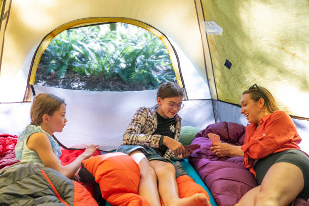 istock Mother and daughters relax in tent 2164712286