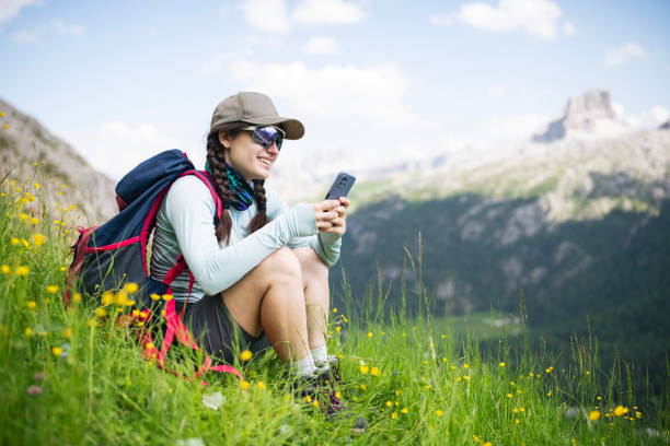 istock Woman on a hike sitting and using phone while resting. 2164713119
