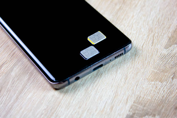 istock 2 sim card next to the smartphone on the table. SIM card cellular communication, operator 2164713760