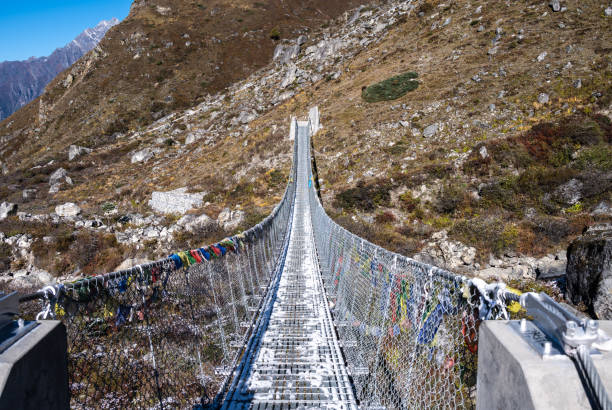 A metal bridge for crossing Langtang Khola river a river coming from the south flows down along the Langtang trekking route, Nepal.