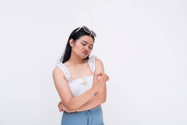 istock A bored asian lady checks her fingernails while waiting. Isolated on a white background. 2164733922
