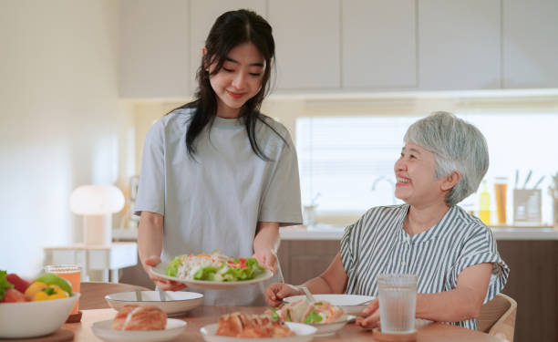 istock Daughter preparing food for her mother 2164734049