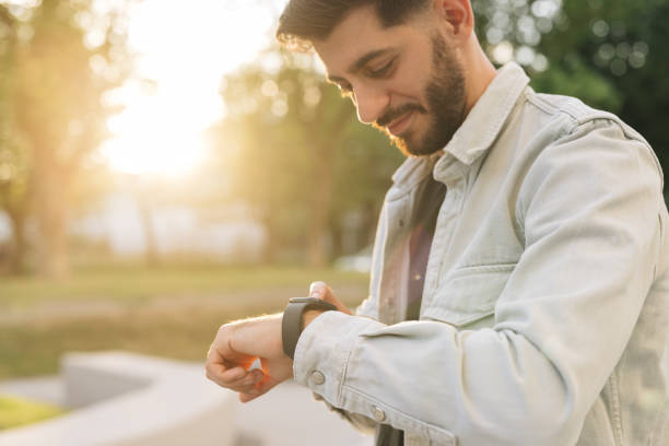 istock Bearded Man Using Smart Watch Wearable Wristband Device. Male Checking Pulse Smartwatch App. Touch Screen Wearable Technology Smart Band. Businessman Scrolling On Display On Smartwatch Notification 2164740669